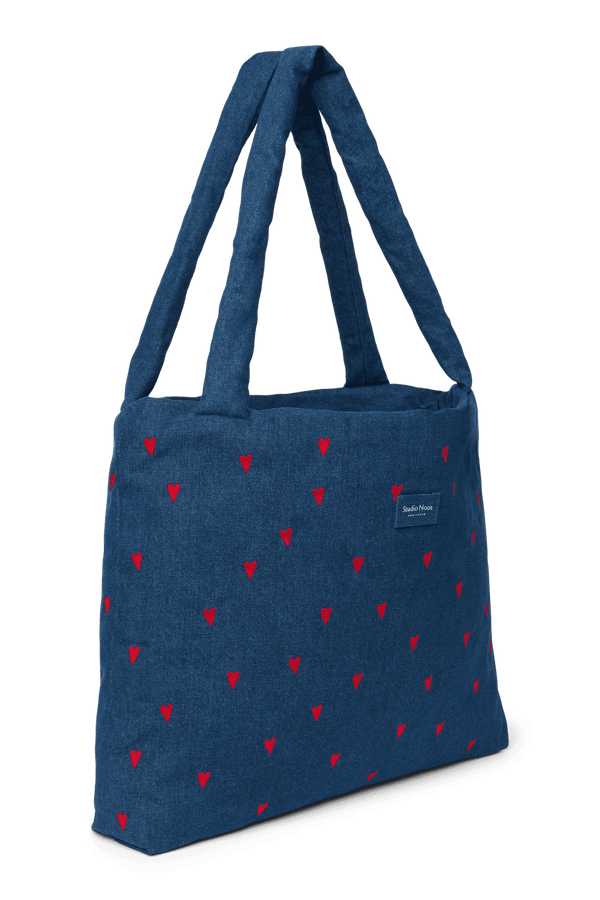 Studio Noos Mom Bag mit roten Herzen über der Schulter getragen