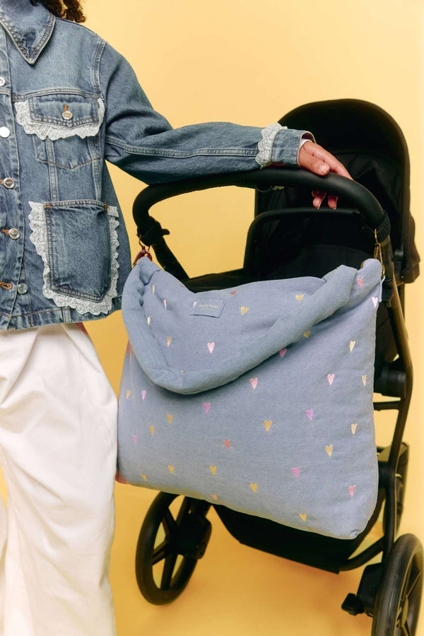 Kleine Herzen auf dem hellblauen Denim der Studio Noos Wickeltasche