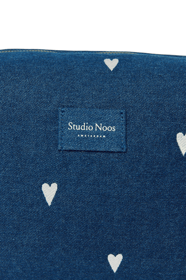 Weisse Herzen auf dunkelblauem Denim des Studio Noos Necessaires