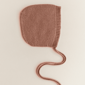 Baby trägt die Bonnette Dolly von Hvid in Terracotta, drinnen wie draussen tragbar