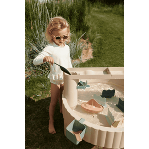Mädchen spielt mit Wasser und Booten am Liewood Sepp Tisch