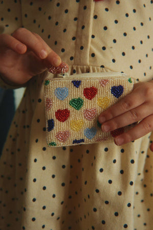 Kind hält das Coeur Coloré Portemonnaie von Konges Sløjd