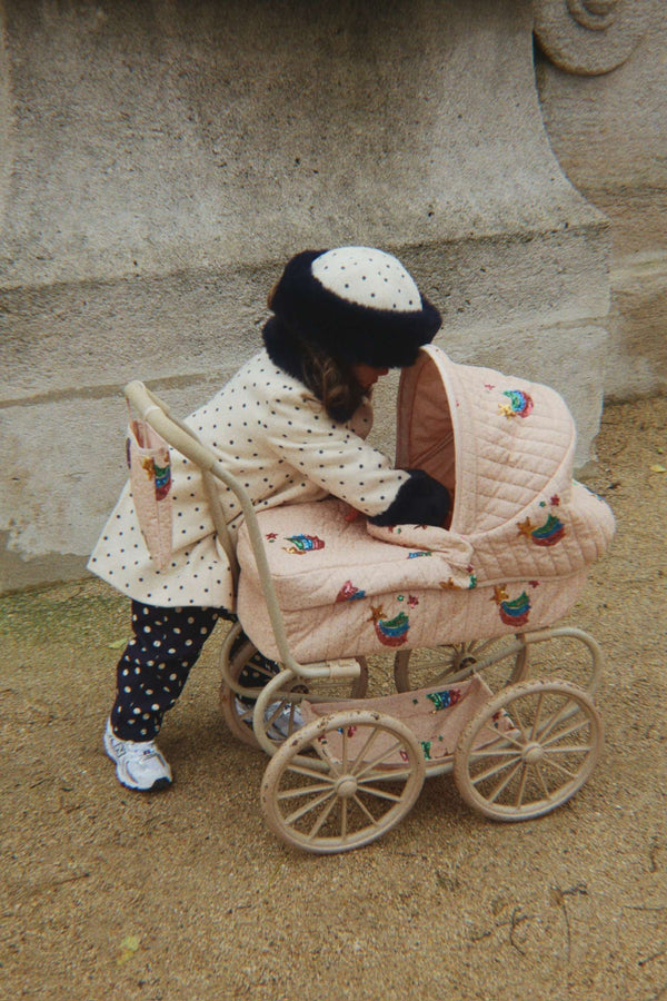 Kind schiebt den niedrigen Tüll-Puppenwagen Minnie von Konges Sløjd am Griff