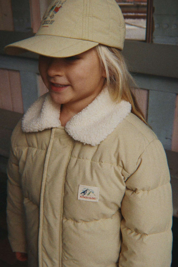 Kind trägt die olivgrüne Alpi Winterjacke von Konges Sløjd