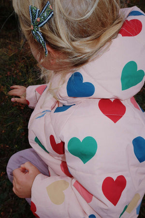 Kind trägt die Nuka Pufferjacke Coeur Rose Coloré von Konges Sløjd