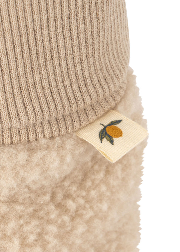 Detail shot of Safa Booties in Oxford Tan, featuring cozy fleece material and a cute lemon tag.