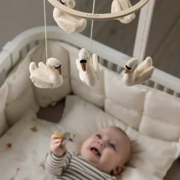Sebra Babymobile Schwäne über dem Babybett aufgehängt