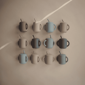Kind trinkt aus dem Mushie Trainingsbecher Powder Blue, ab 6 Monaten
